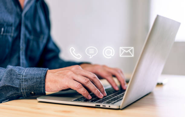 istock Hotline service, Customer support hotline Contact us people connection. Businessman using laptop with the email, call phone, address, Chat message icons 1449580217