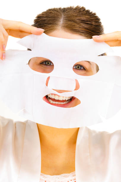 istock Woman applying sheet mask on face 1449582170
