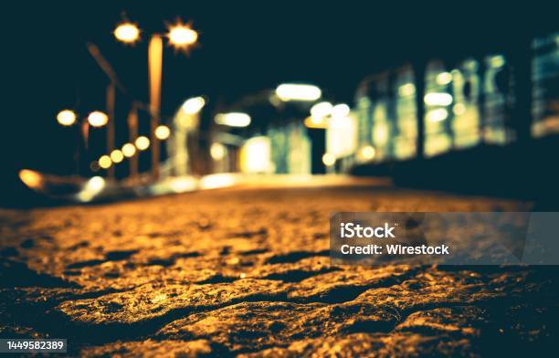 Closeup Shot Of Rough Road With Yelllow Light Reflection On The Surface Stock Photo - Download Image Now