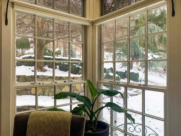 Cozy screened porch winter during Holidays season, snowy roofs and woods in the background.