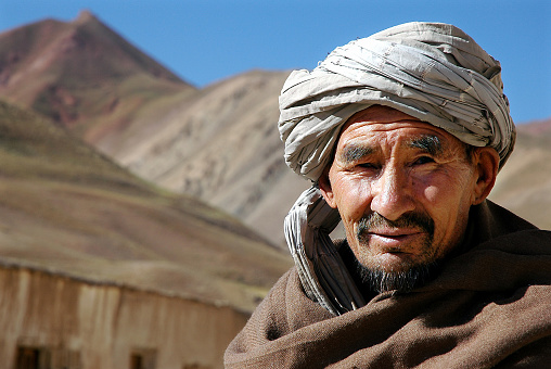 Syadara (Siyah Darah), Bamyan (Bamiyan) Province / Afghanistan: An Afghan man in the small town of Syadara in Central Afghanistan. Man with turban and beard with mountain backdrop.