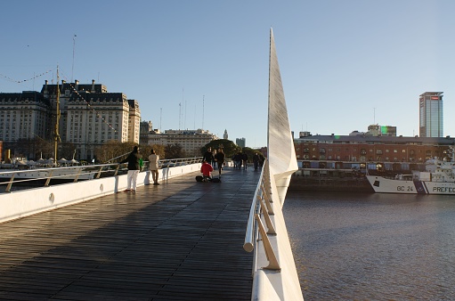 Buenos Aires, Argentina – June 26, 2019: The rotating footbridge of Puente de la Mujer and people walking on it in Buenos Aires, Argentina