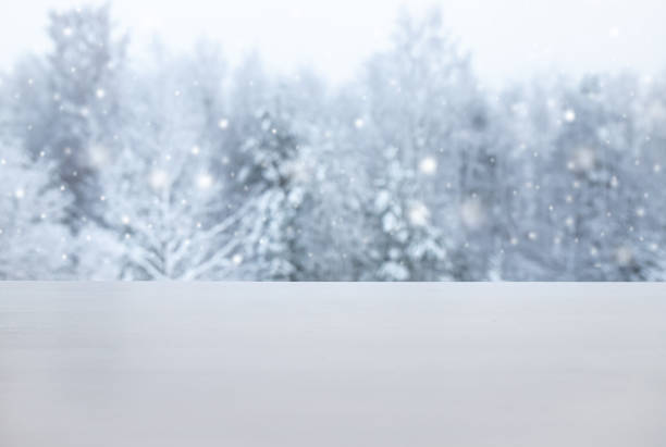 istock Winter products advertising background. Focus on white table with white magical snowy trees on background. Lot of copy space. Not actually manipulation, shot outside. 1449583781