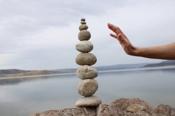 istock A hand constructs equilibrium on pebbles. Perfect balance of stack of pebbles on the seashore. Concept of balance, harmony and meditation. Helping or supporting someone for growing or going higher. 1449583921