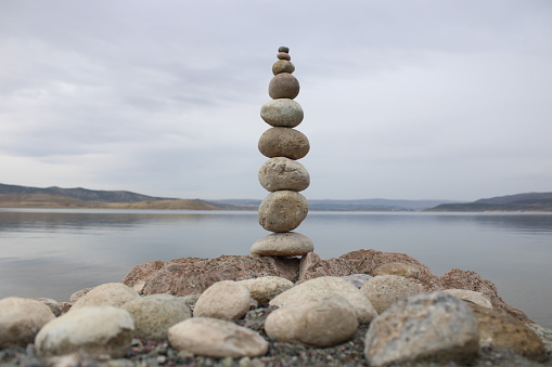 stack of stones on the beach. Various stones top view on the beach. Stone Tower, Land Art, Installation, Stones. stones in balance. Mindfulness themed photo.