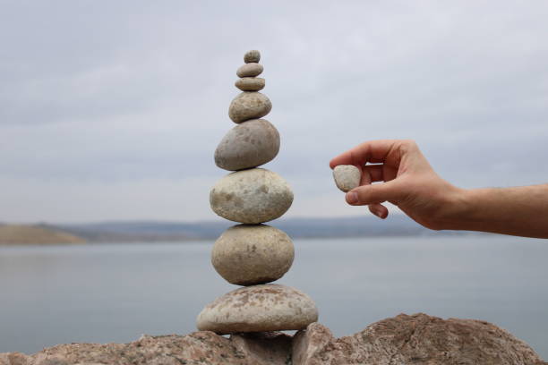 istock A hand constructs equilibrium on pebbles. Perfect balance of stack of pebbles on the seashore. Concept of balance, harmony and meditation. Helping or supporting someone for growing or going higher. 1449583976