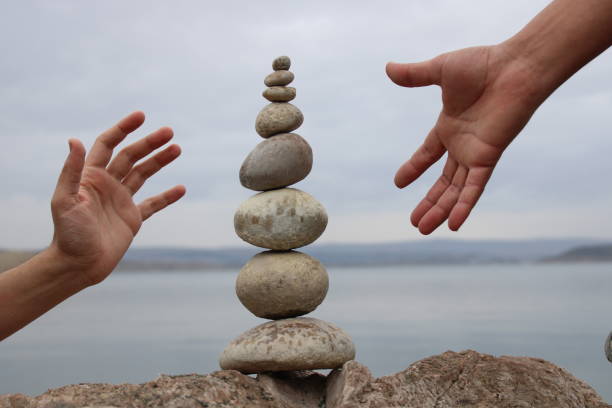 istock A hand constructs equilibrium on pebbles. Perfect balance of stack of pebbles on the seashore. Concept of balance, harmony and meditation. Helping or supporting someone for growing or going higher. 1449584017