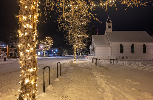 Canmore, Alberta, Canada – November 28, 2022:  Christmas lights and church on Main Street at night