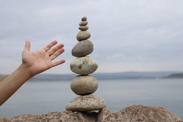 istock A hand constructs equilibrium on pebbles. Perfect balance of stack of pebbles on the seashore. Concept of balance, harmony and meditation. Helping or supporting someone for growing or going higher. 1449585111