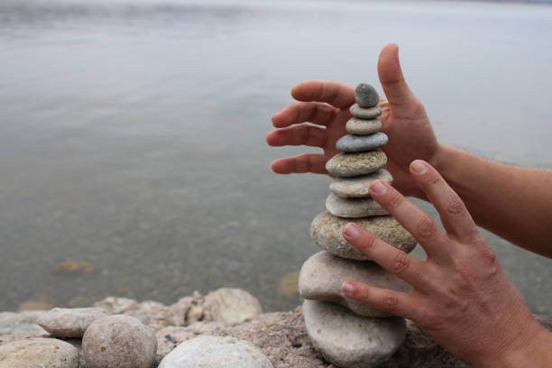 istock A hand constructs equilibrium on pebbles. Perfect balance of stack of pebbles on the seashore. Concept of balance, harmony and meditation. Helping or supporting someone for growing or going higher. 1449585123