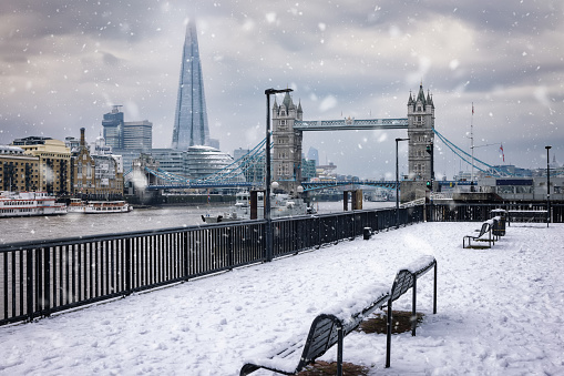 Beautiful winter view of the London skyline covered in snow and ice with snowflakes falling from the cloudy sky