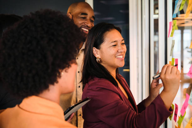 istock Laughing businesspeople having a brainstorming session in an office 1449587593