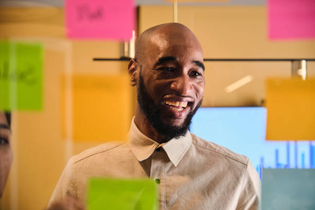 istock Businessman laughing during an office brainstorming session with adhesive notes 1449587883