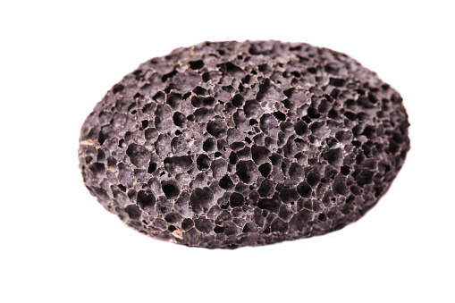 Black natural porous pumice stone isolated on white background.