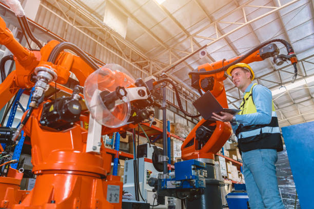 istock Worker man working with robot arm automate welding machine in modern metal factory. Engineer program robotic in heavy industry. 1449589329