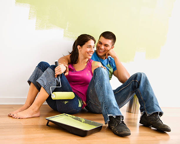 Smiling couple with painting materials.