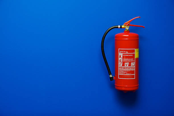 Fire Extinguisher in Office Fire extinguisher on the blue wall fire extinguisher photos stock pictures, royalty-free photos & images