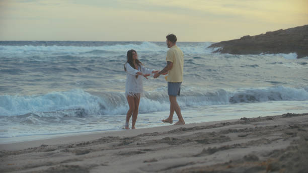istock Romantic couple on a beach. Loving couple playing in the waves 1449598596