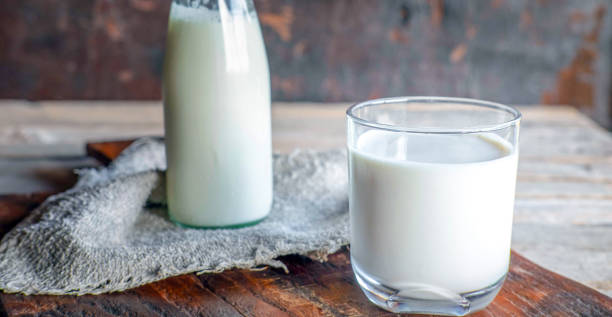 istock Bottles and milk glasses on a wooden table 1449598765