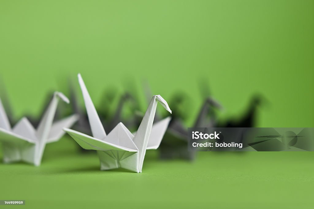 Origami cranes A group of white, grey and black origami cranes on a green background Bird Stock Photo