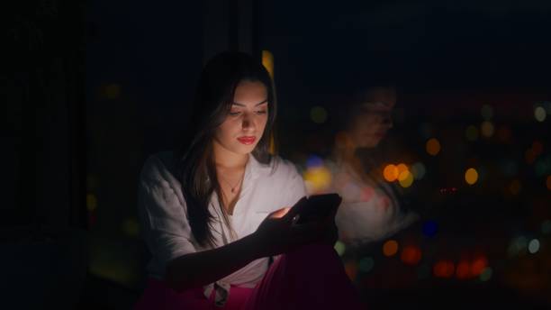 istock Young woman using smart phone at home at night 1449599986