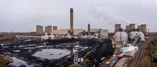 Drax Power Station, UK - November 27, 2022.  Aerial panorama view of a large coal fired power plant with low stocks of coal and storage tanks for Biofuel and carbon capture