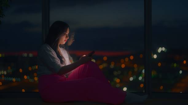 istock Young woman using smart phone at home at night 1449600058