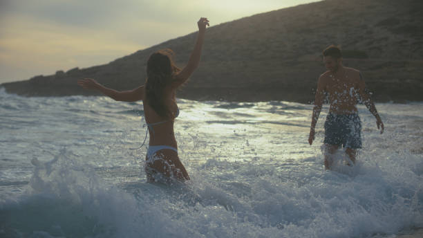 istock Romantic couple on a beach. Playing in the sea waves 1449600143