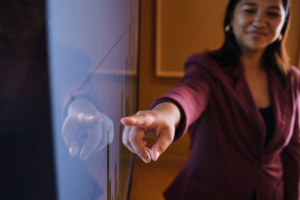 istock Smiling businesswoman explaining a graph on a monitor during a presentation 1449601600