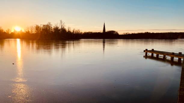 istock Frozen lake in the Netherlands with ice skaters at sunset 1449603818