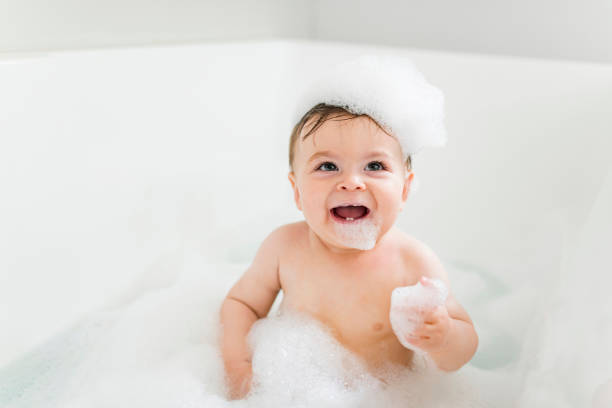 istock Baby boy bathes in a bath with foam and soap bubbles 1449605375