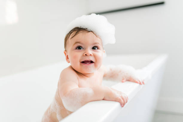 istock Baby boy bathes in a bath with foam and soap bubbles 1449605378