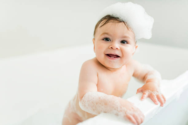 istock Baby boy bathes in a bath with foam and soap bubbles 1449605380