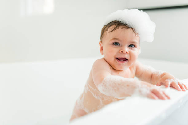 istock Baby boy bathes in a bath with foam and soap bubbles 1449605381
