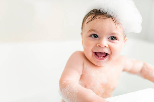 istock Baby boy bathes in a bath with foam and soap bubbles 1449605382
