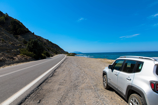 Vacation with a rental car. 4x4 SUV Jeep Renegade on asphalt road on Rhodes island, Greece