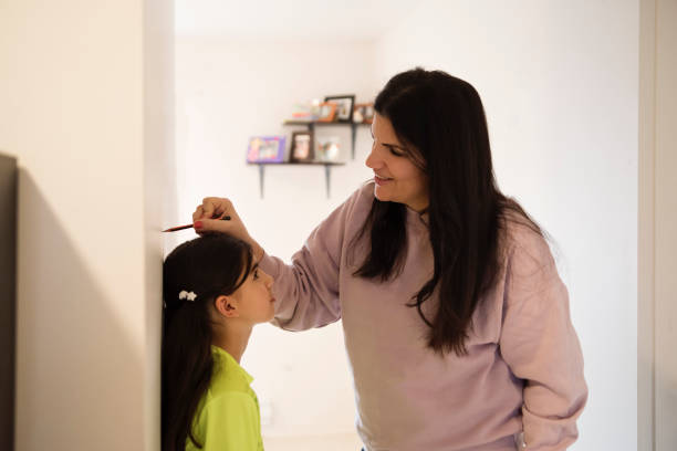 istock Middle eastern mother measuring daughter at home. 1449614613