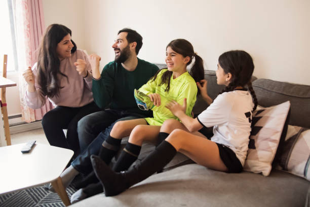 istock Middle eastern family watching a soccer game on television. 1449615718