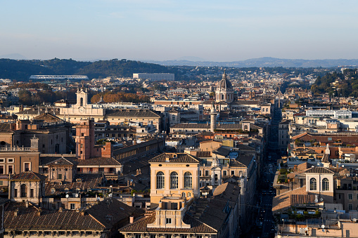 The golden rays of sunset illuminate the center of the city of Rome seen from the panoramic terrace of the Altare della Patria.\nIn the foreground via del Corso with its domes and monuments such as the Roman Column of Marc'Aurelio.\nIn the background, Monte Mario and the 'Olimpico' football stadium.