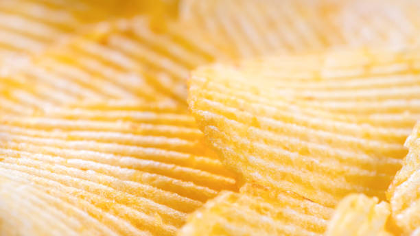 istock Yellow crispy ridged potato chips close up. Food background 1449616519