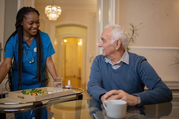 istock Retired man with female home carer 1449617065