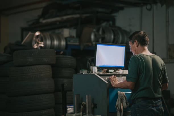 istock Asian Chinese senior mechanic working on car tyre wheel alignment with computer analysis data 1449617135