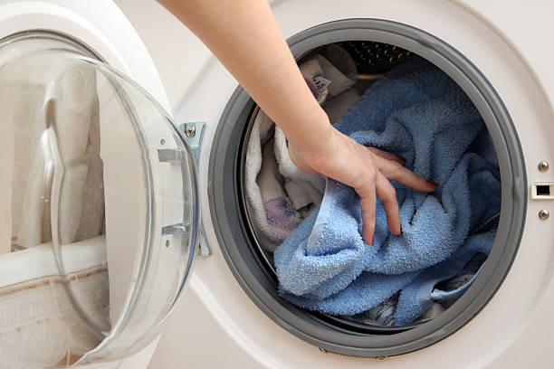 istock Woman's hand pushing cloths into a washing machine 144961735