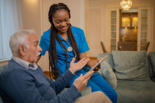 istock Retired man with female home carer 1449617927