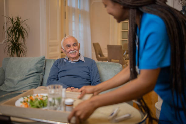 istock Retired man with female home carer 1449618125