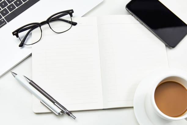 istock White cup of coffee on a desktop with various office appliances 1449618126
