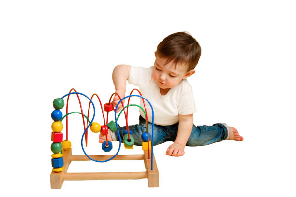 istock Toddler baby is playing logic educational games on a studio isolated on a white background. Happy child play with educational toy, learning logic. Kid aged one year four months 1449618150