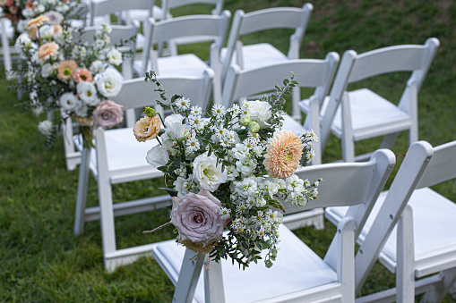 white wooden chairs with flower on a green lawn.