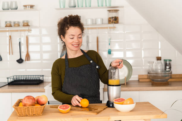 istock Happy girl making fresh juice in a blender 1449619921