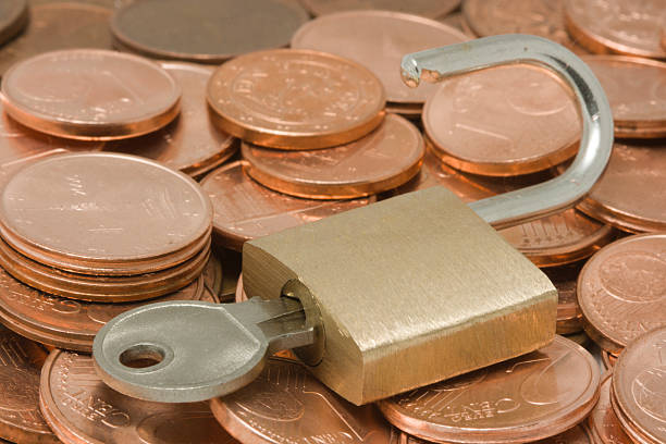 istock Opened padlock with key on top of coins 144962041